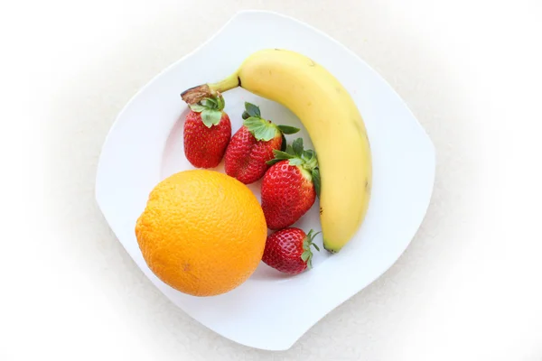 Fresh fruits on a white plate — Stock Photo, Image