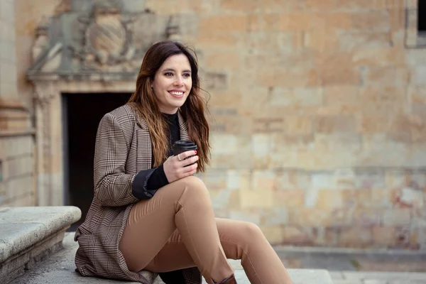 女孩在街上喝咖啡 面带微笑 — 图库照片