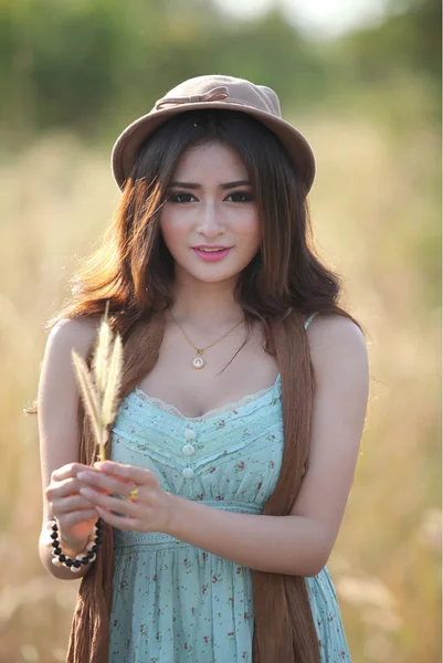 Beautiful woman in field of meadow hat and scarf — Stock Photo, Image