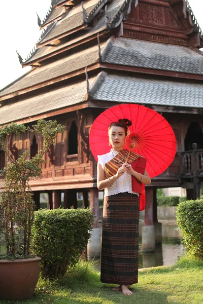 Красивая тайская женщина с красным зонтиком — стоковое фото