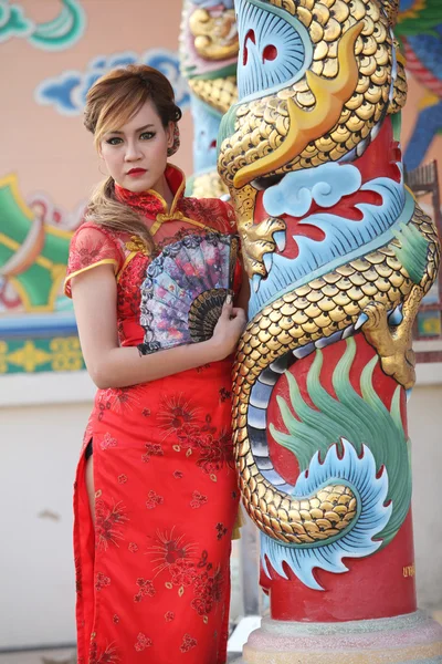 Mulher de vestido chinês ficar ao lado de um pólo — Fotografia de Stock