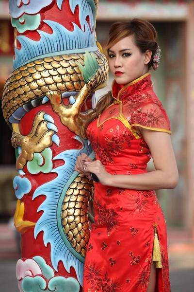 Mulher de vestido chinês ficar ao lado de um pólo — Fotografia de Stock