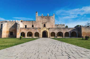 San Bernardino de Siena Manastırı 'nın ön cephesine giden yol Valladolid, Yucatan, Meksika' da çimen tarlasıyla doludur.