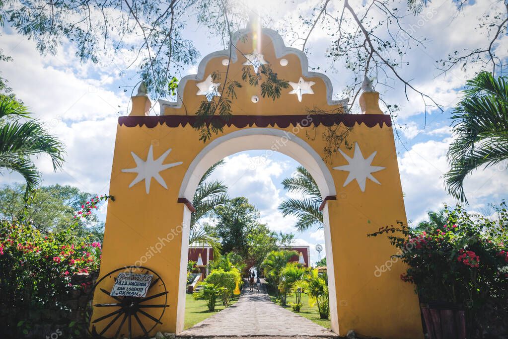 Traditional yellow hacienda entrance leading into garden at the San Lorenzo Hacienda at the Oxman Cenote, Yucatan, Mexico