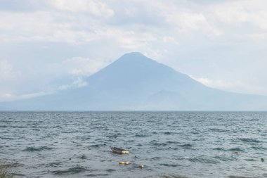 Guatemala, Panajachel 'deki volkan manzaralı güneşli göl Atitlan' da küçük bir tekne.