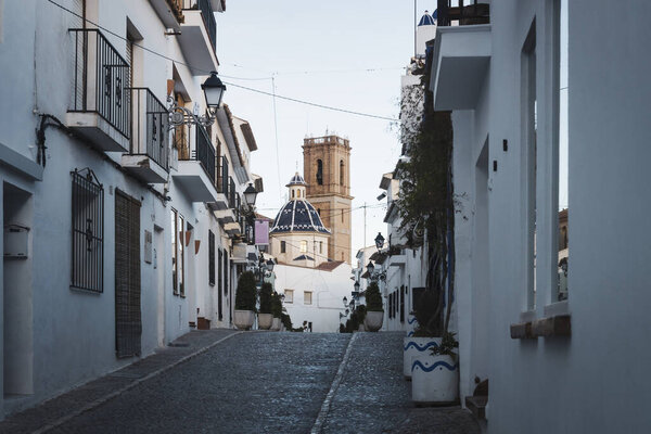 Old town of Altea with cobblestoned street and view on blue domed cathedral and clock tower, Altea, Costa Blanca, Spain