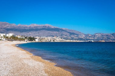 Albir, Costa Blanca, İspanya 'dan Altea manzaralı Akdeniz kıyısındaki taş plajı