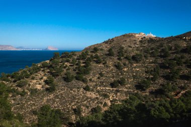 Sunny Natural Park Serra Gelada deniz feneri ve arka planda Calpe Rock 'Ifach, Albir, Costa Blanca, İspanya