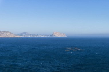 Akdeniz 'de balık çiftliği ve dağ sıraları ve Calpe, Albir, Costa Blanca, İspanya' nın kaya 'Ifach' ı