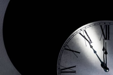 Roma rakamlarının bulunduğu klasik duvar saati, zamanın tükenmesinin sembolü olarak gece yarısına beş dakika var.