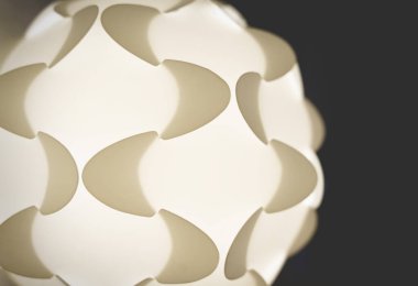 Detail of a white illuminated puzzle lamp from the sixties with geometric shapes clipart