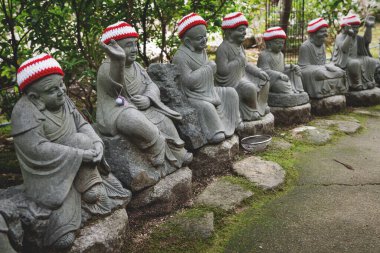 Miyajima, Hiroşima, Japonya 'daki Diasho-in tapınağındaki tarihi Buda Shakyamuni' nin ilk 500 havarisini temsil eden örgü şapkalı Buda heykelleri.