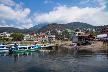 Santiago Atitlan, Guatemala - 20 Mart 2018: Santiago Atitlan, Guatemala 'daki renkli evlere bakan Atitlan Gölü kıyısında güneşli iskele