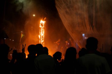 Ziyaretçilerin siluetleri, İspanya 'nın Gandia kentindeki Fallas festivali için yanan heykelleri söndüren ferahlatıcı su spreyinin keyfini çıkarıyor.