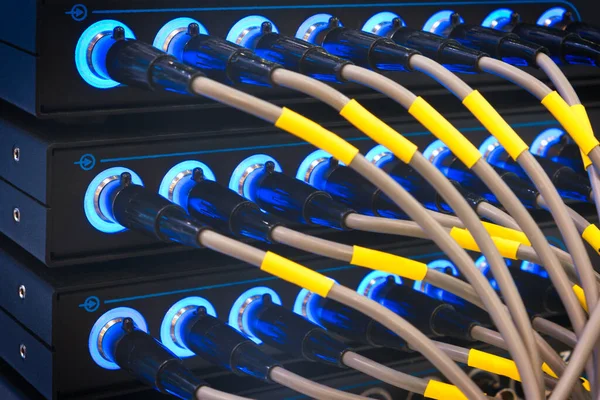 Wires connected to the network server, optical fiber. Network cables closeup with fiber optical background