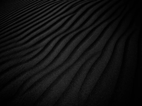 Black and White Sand beach macro photography. Texture of black and whote sand for background. Close-up macro view of volcanic sand surface black and white color. Black and white poster texture sand in the desert.