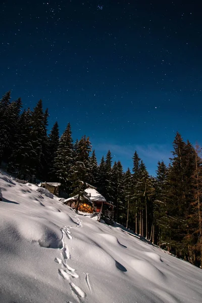 The chalet in the mountains in winter time at night