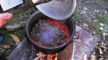 Bahçedeki odun ateşinde ezilmiş sebze pişirmek geleneksel yemektir.