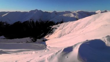 Gün batımında kış mevsiminde zirvelerden nefes kesici dağ manzarası