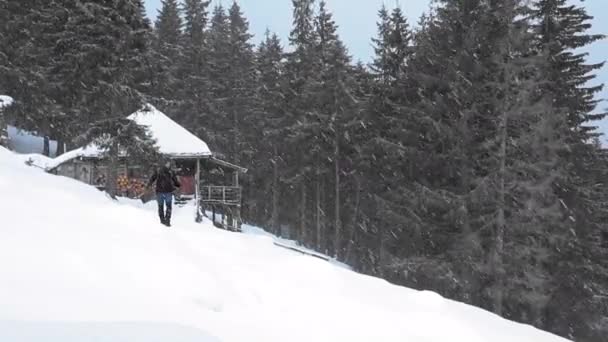 Wędrowiec Spacerujący Śniegu Pobliżu Górskiego Domku — Wideo stockowe