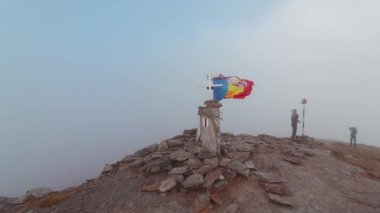 Rüzgarlı bir günde dağın tepesinde üç renk bayrağı