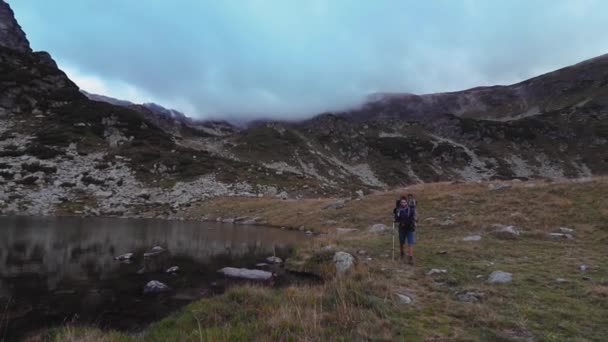 Twee Wandelaars Lopen Berg Met Galciaal Meer Een Bewolkte Dag — Stockvideo