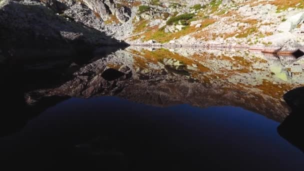 秋の岩だらけの山の中の美しい氷河湖の反射 — ストック動画