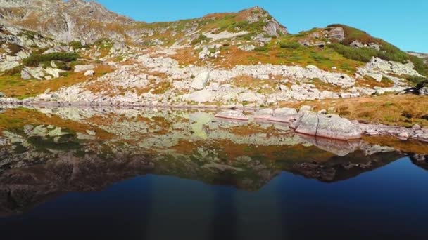 秋の岩だらけの山の中の美しい氷河湖の反射 — ストック動画