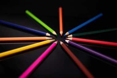 Siyah arkaplanda renkli kalem grubu