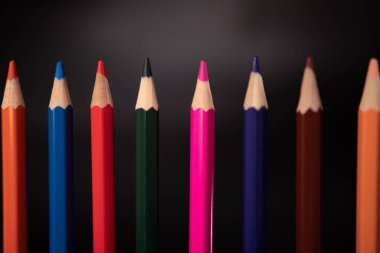 Siyah arkaplanda renkli kalem grubu