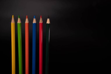 Siyah arkaplanda renkli kalem grubu