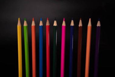 Siyah arkaplanda renkli kalem grubu