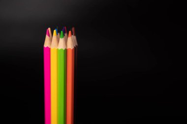 Siyah arkaplanda renkli kalem grubu