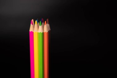 Siyah arkaplanda renkli kalem grubu