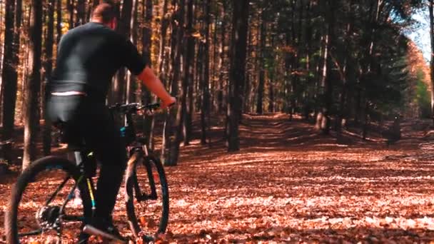 Muž Kole Lese Barevnými Listy Během Podzimu — Stock video