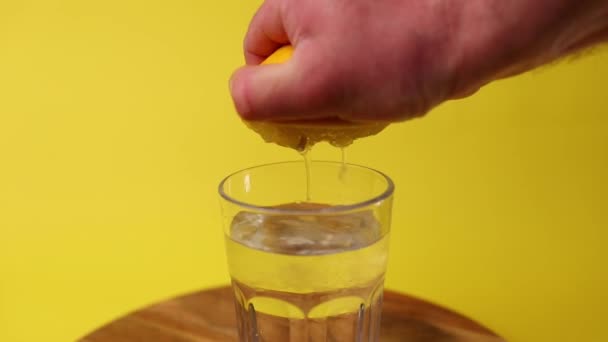 Geperste Citroen Een Glas Met Mineraalwater Gele Achtergrond — Stockvideo