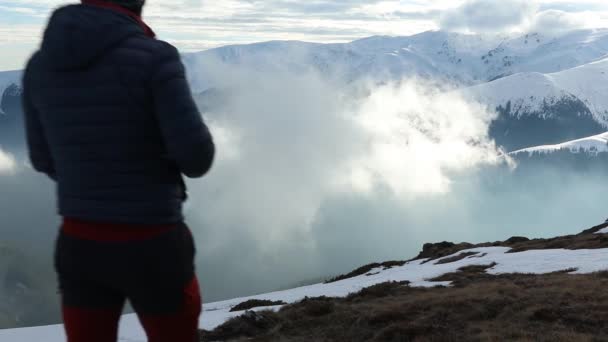 霧の多い日には冬の山の景色を楽しむハイカーや犬 — ストック動画