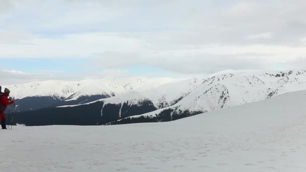 冬は高い山の中で雪の上を歩くハイカー — ストック動画