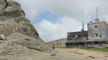 Bir yürüyüşçü yazın dağın zirvesine ulaşır.