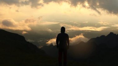 Yalnız yürüyüşçü, yüksek dağdan sisli bir sabahta baş döndürücü bir gündoğumuna hayran.