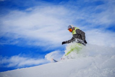 Snowboardcu dağda fren yapıyor ve kar bulutu yapıyor. Sporcu Gudauri, Georgia 'da snowboard yapıyor.