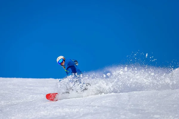 スノーボーダーブレーキと山の中で雪の雲を作る ジョージア州グドーリのスノーボードに乗るスポーツマン ストック画像