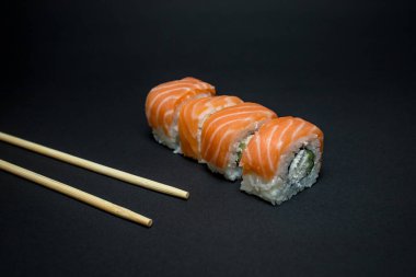 Siyah arka planda Japon mutfağı suşisi. 
