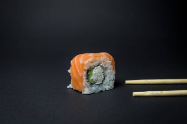Siyah arka planda Japon mutfağı suşisi.