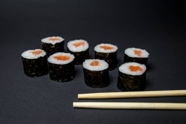 Siyah arka planda Japon mutfağı suşisi.