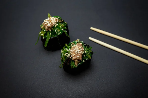 Sushi Japonés Con Palillos Sobre Fondo Negro Imagen de archivo