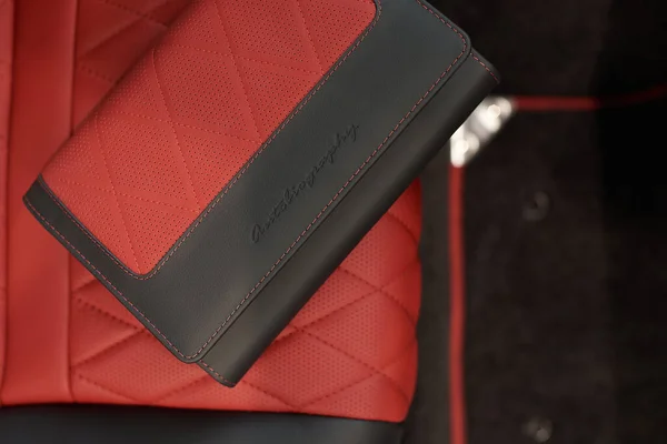 Arka koltukta pahalı bir arabanın markalı kitabı var, Range Rover otobiyografisi.