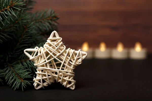 Arka planda mumları olan bir Noel ağacının yanında dönen beyaz bir yıldız.