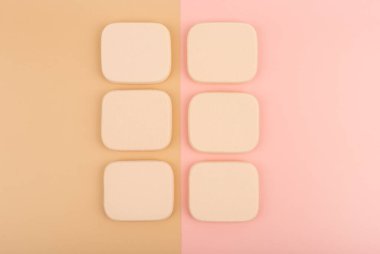 Renkli pembe ve bej arka planda bej makyaj süngeri