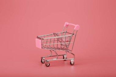 Pembe arka planda alışveriş arabası